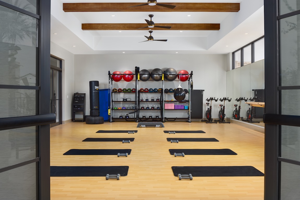 Community gym with weights and yoga mats.