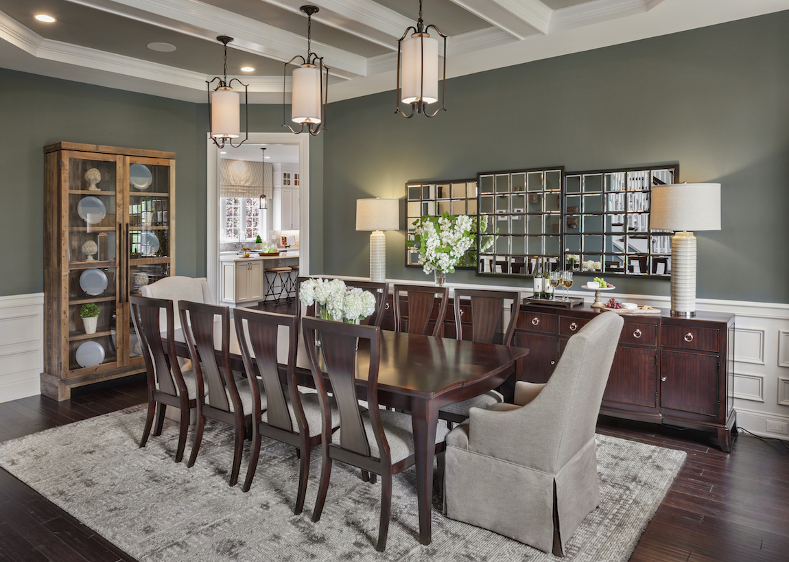 A luxury dining room with green colored walls and a chandelier.
