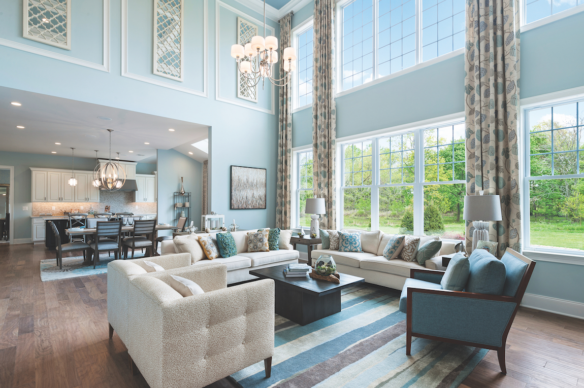 A luxury home with teal colored walls, a chandelier and tall ceilings.