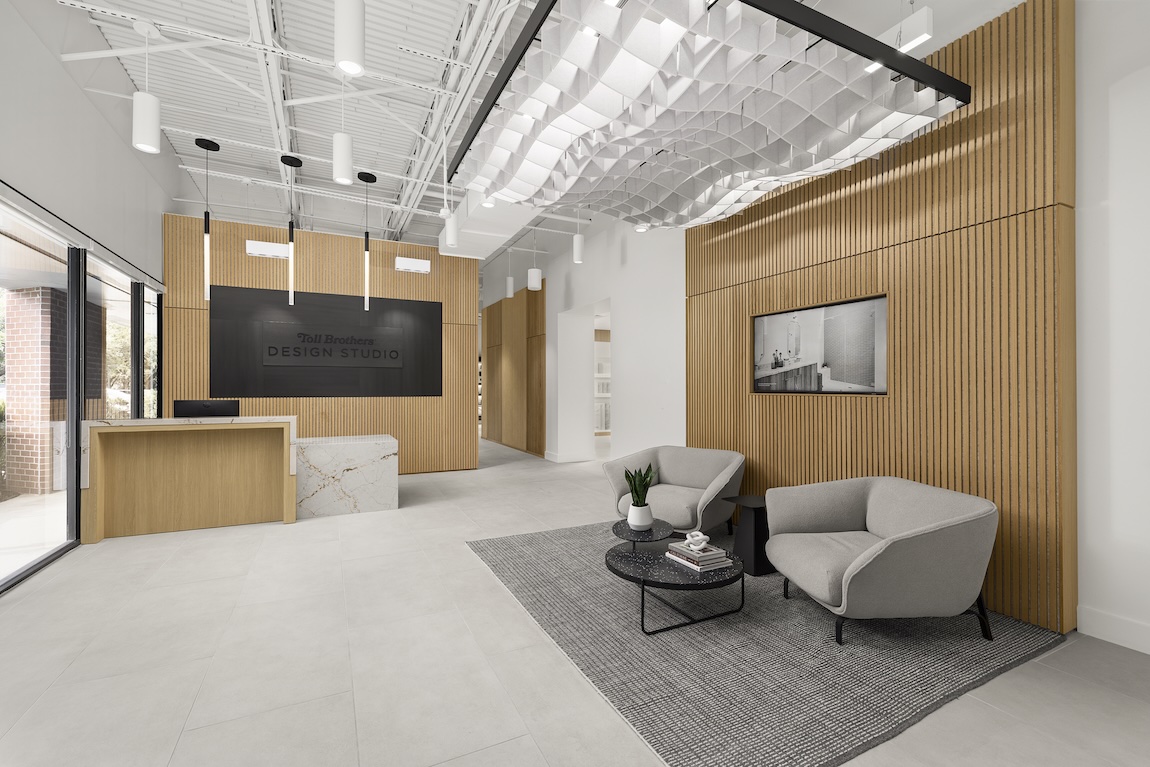 Modern Toll Brothers Design Studio lobby in Bonita Springs, FL, with wood slat detailing, contemporary seating, and upscale interior finishes.