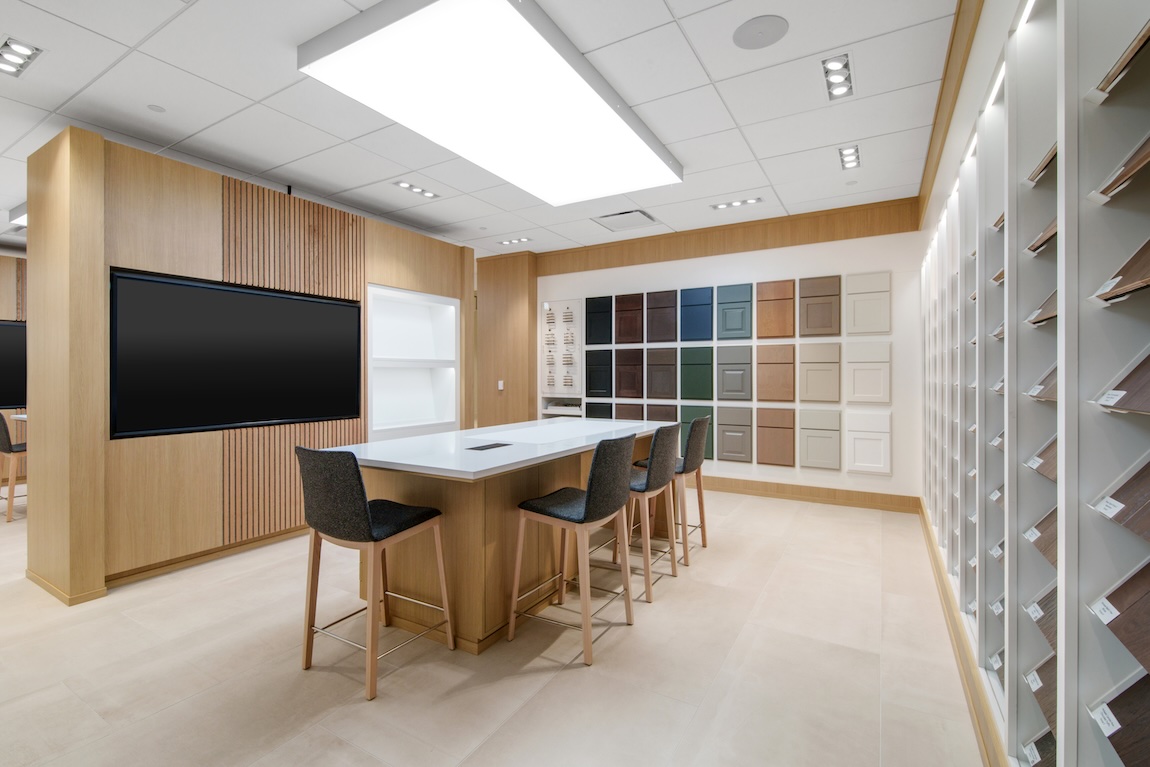 Interactive selection area featuring cabinetry samples, flooring displays, and design consultation workspace.