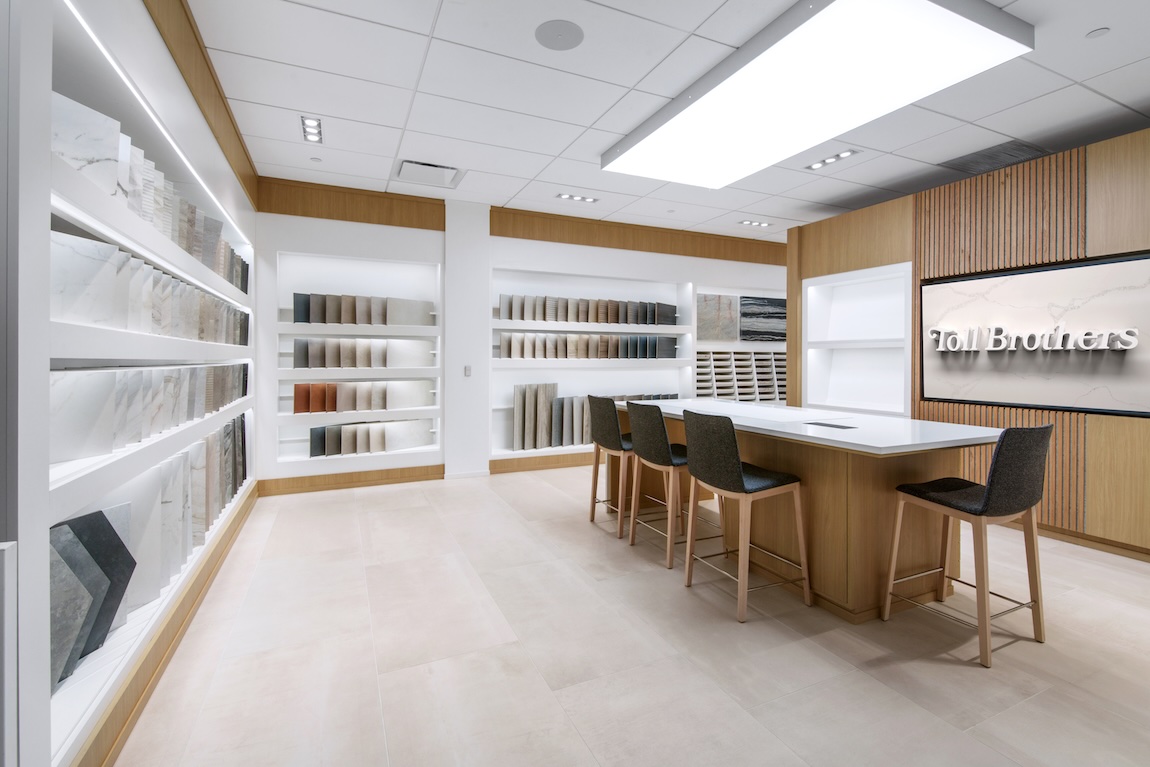 Tile and surface material displays with illuminated shelving and collaborative design tables.