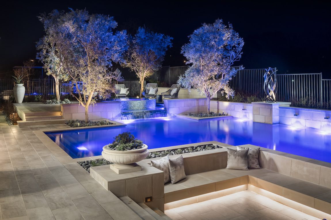 Beautiful landscaping featuring an outdoor pool with sitting area.