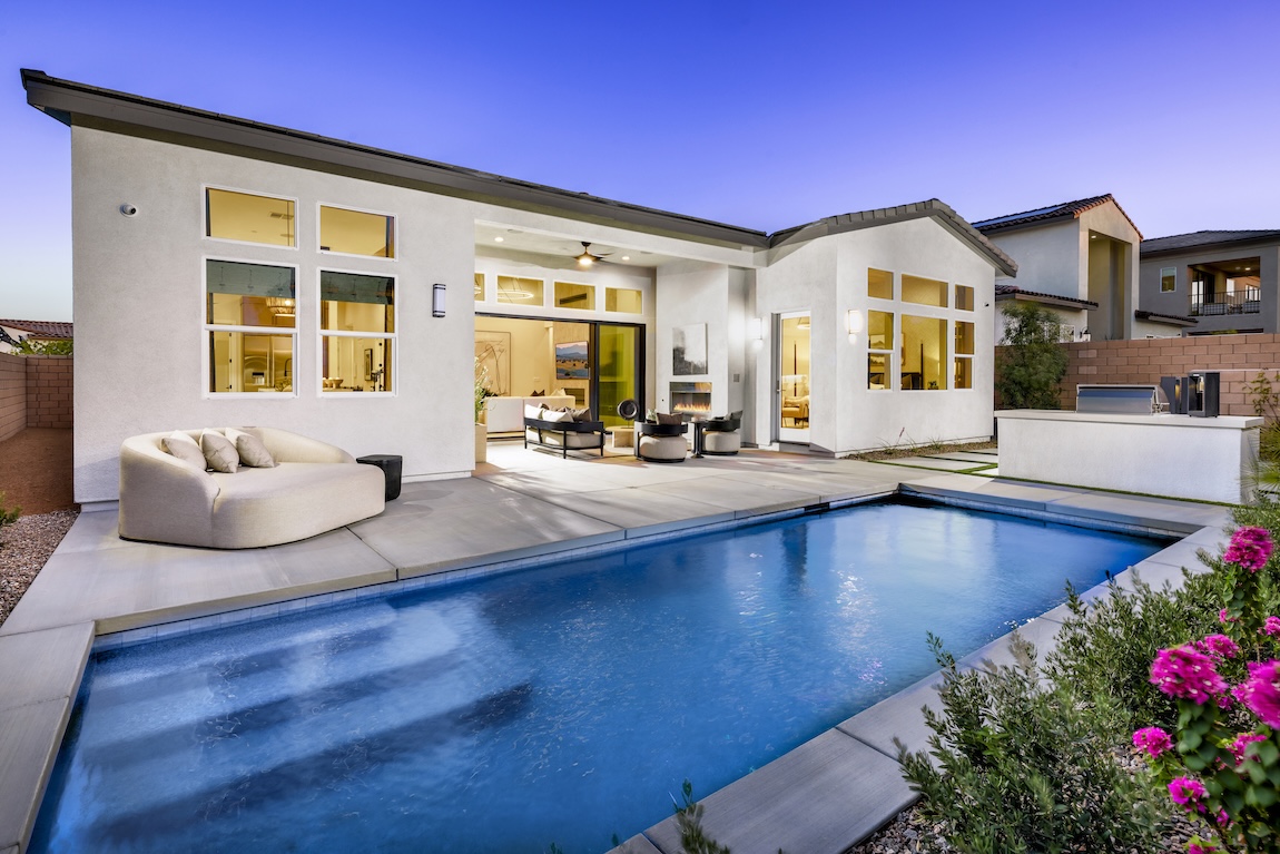 backyard pool with warm interior lighting