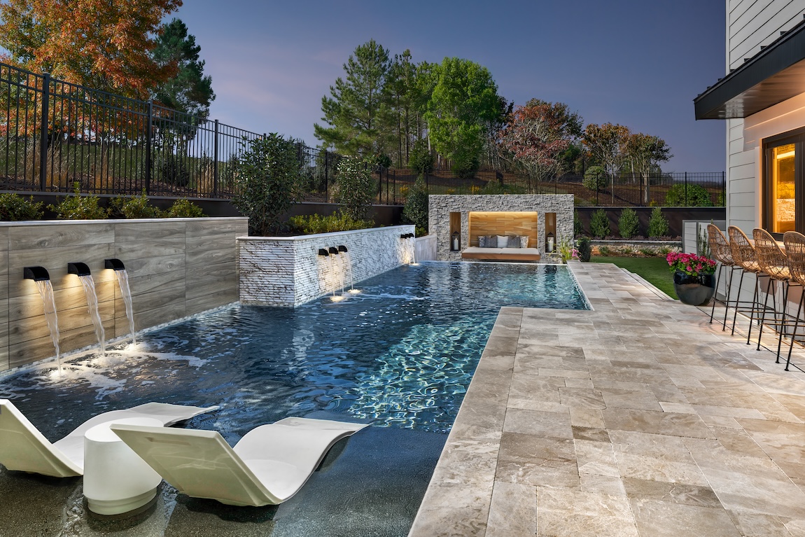 backyard pool with lounge seating and lighting