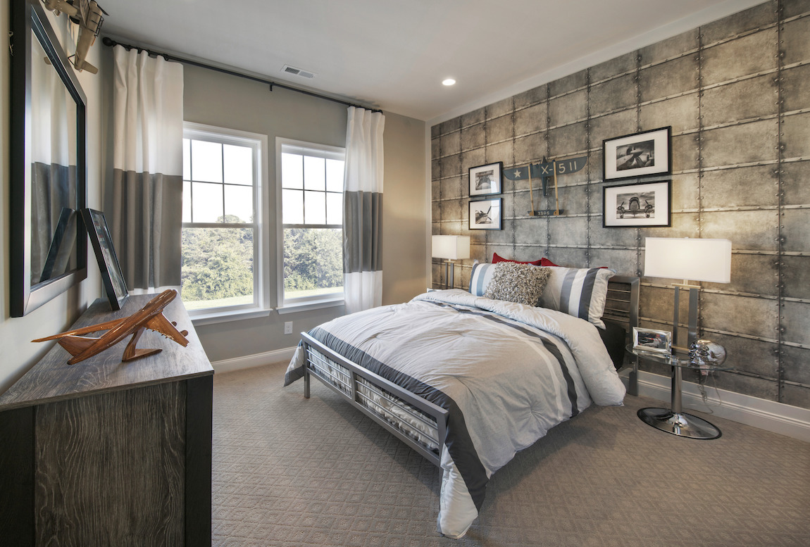 Teen bedroom highlighted by pictures, decorative pieces, and wall paneling geared towards aviation theme