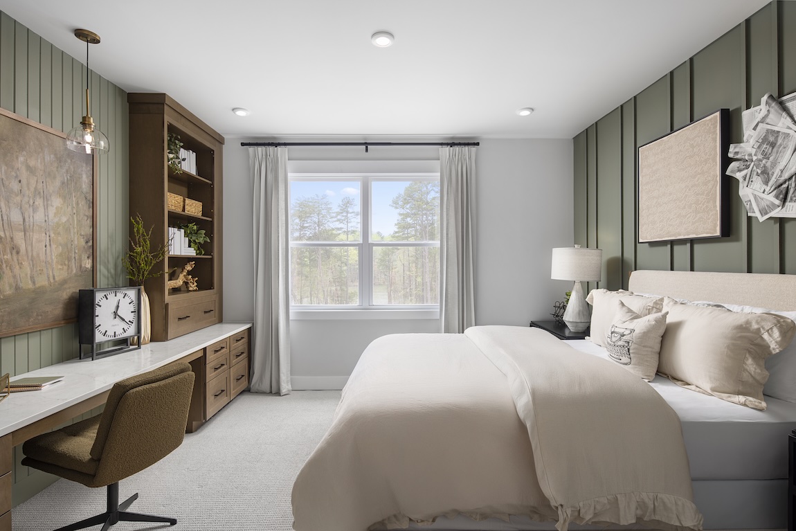 bedroom with green accent walls and desk space