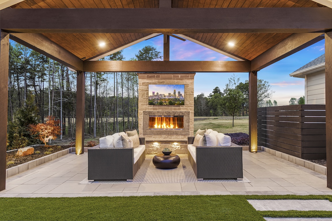 backyard patio with fire place and lighting