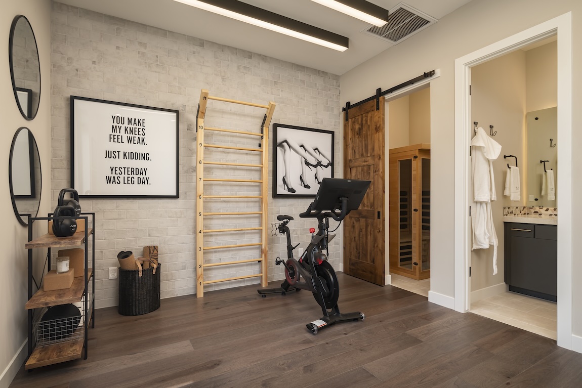 modern home gym with equipment and access to a sauna 