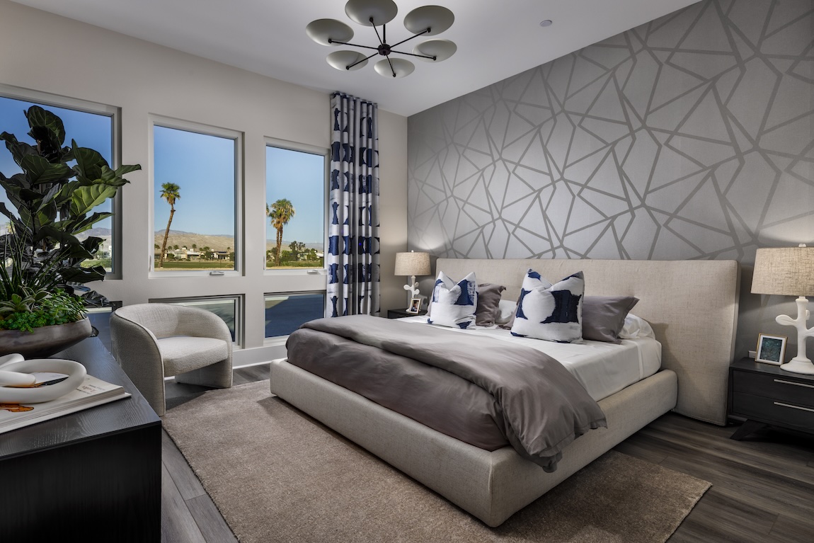 bedroom with geometric accent wall and views of palm trees