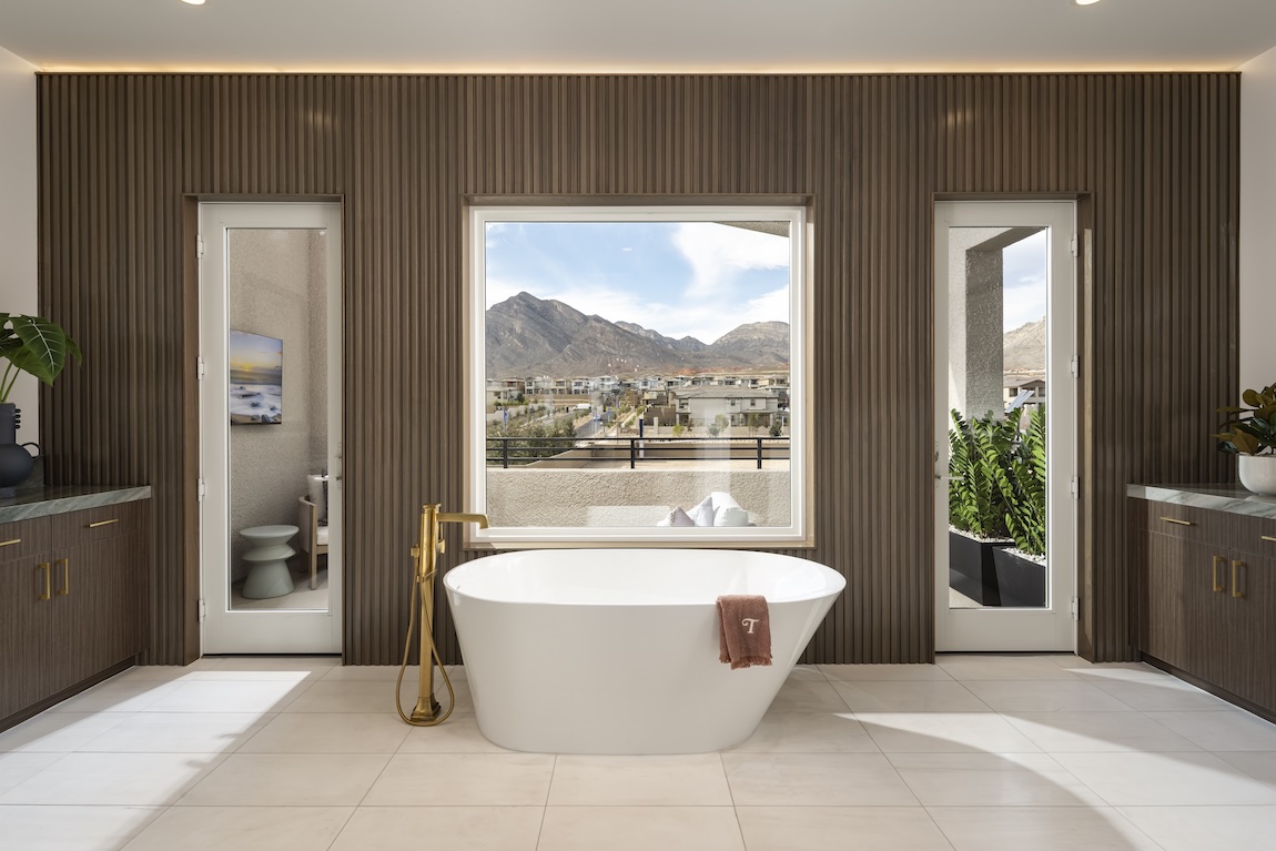 primary bathroom with freestanding tub and a stand out accent wall