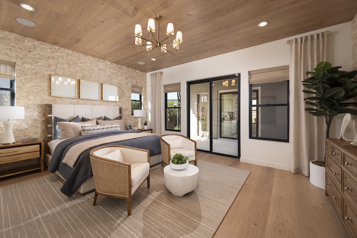 primary bedroom with stone accent wall and sliding doors to outdoors