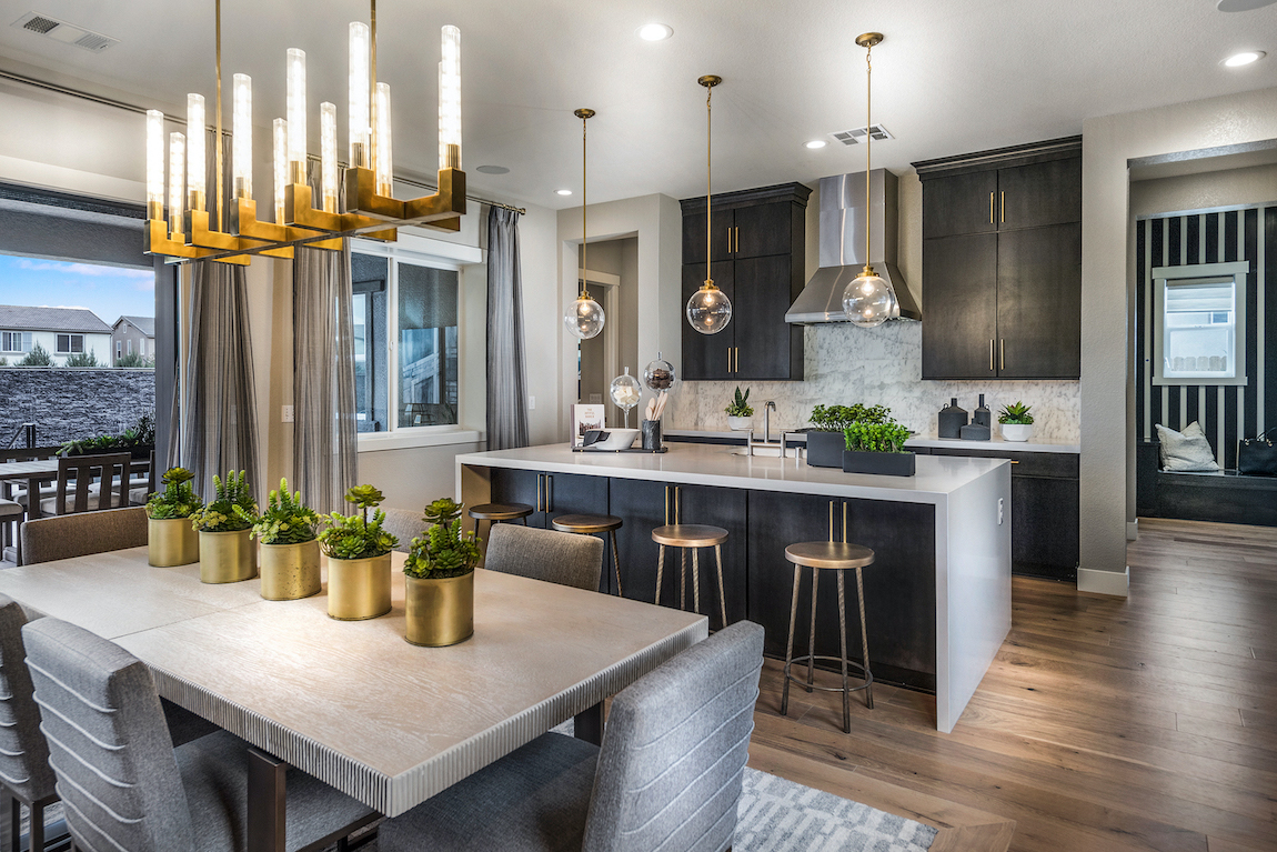 Kitchen with marble countertop and black painted island with a rectangular breakfast nook table.
