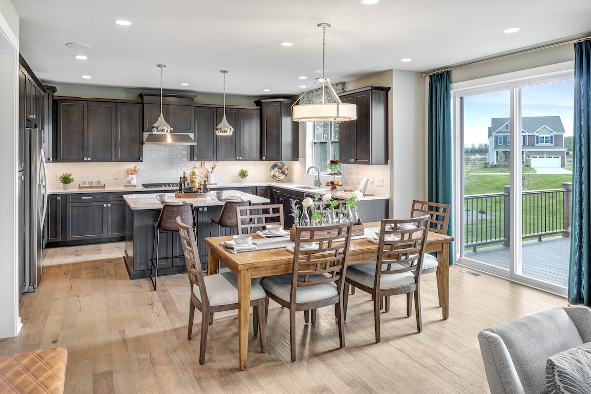 Kitchen nook with breakfast area and wooden chairs and table.