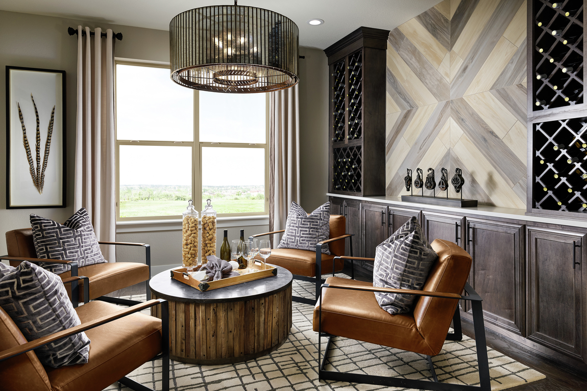 Study with wine storage and leather brown chairs.