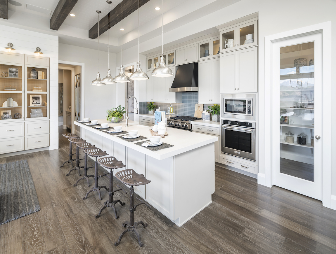 Kitchen with white quartz island countertop and metal stools