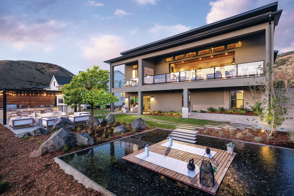 Backyard with large balcony overlooking outdoor patio and seating areas.