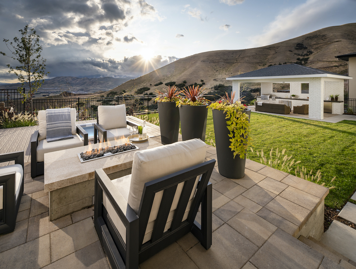 Utah home backyard with greenery, mountains, and patio.