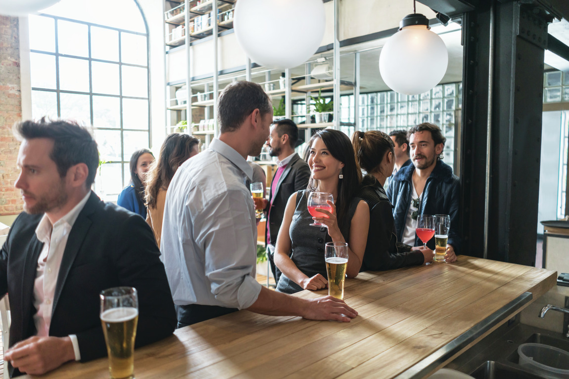 Young adults in a bar having drinks and sharing conversation