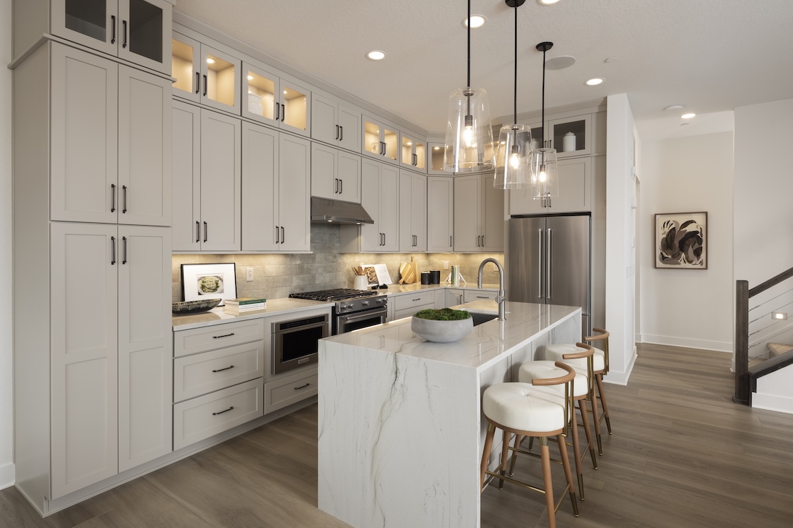modern farmhouse kitchen with circular stools and glass pendant lights