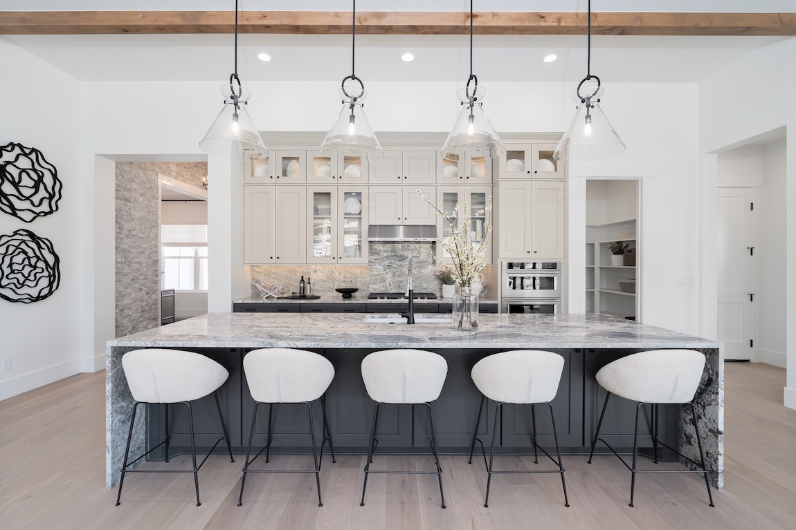 modern kitchen with waterfall island and glass pendant lights