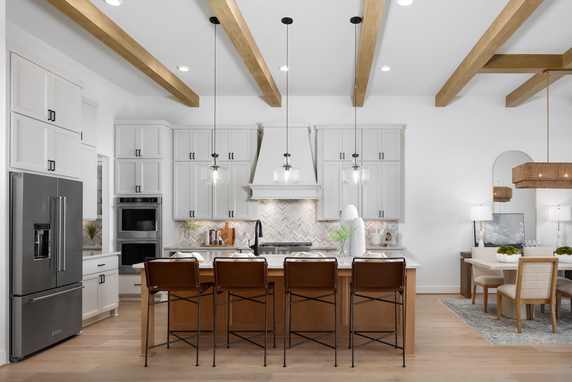 modern kitchen with leather barstools and wood beamed ceiling