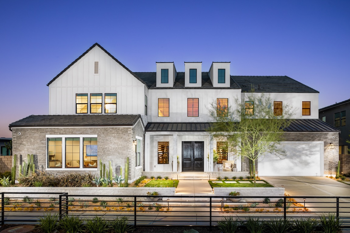 modern farmhouse exterior with lighting illuminating the landscaping in the front of the home