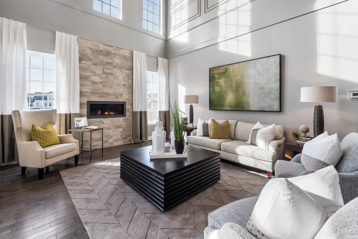 A large living room lots of natural windows and a ledge stone fireplace.