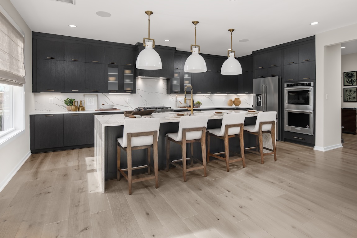 modern farmhouse kitchen with pendant lights and gold fixtures