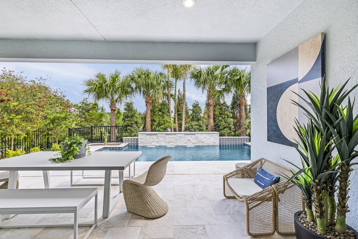 outdoor covered patio with dining table and pool views