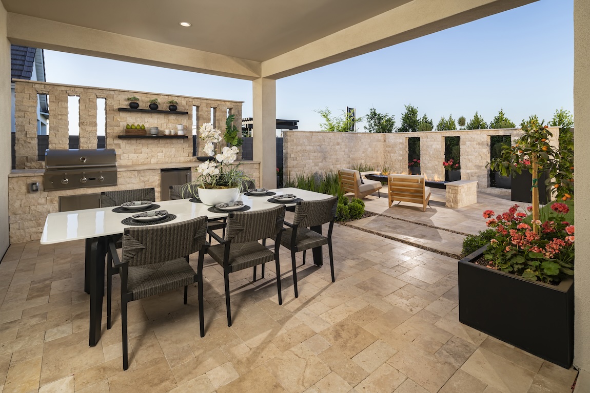 luxe outdoor kitchen space with grill and dining area, adjacent to fire pit lounge