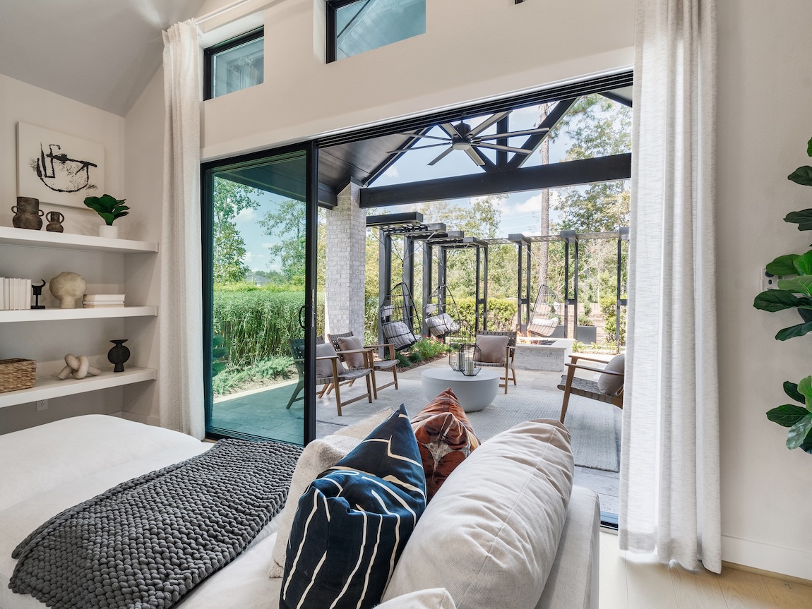 Texas home design featuring a bedroom with indoor-outdoor transition to patio