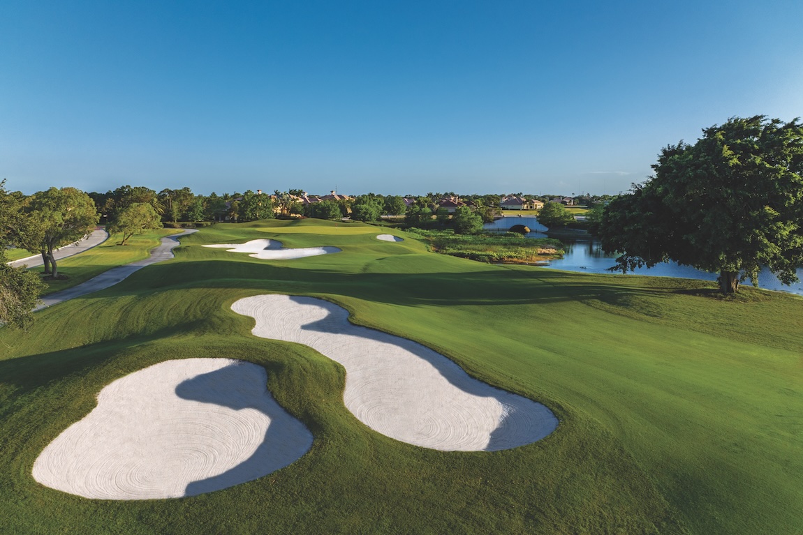 Scenic golf course community with manicured fairways, white sand bunkers, water features, and surrounding homes.