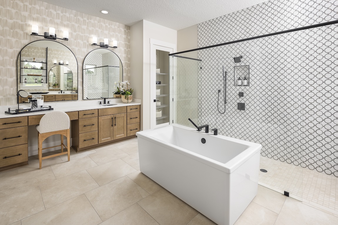 primary bathroom with freestanding tub and patterned tile in the shower