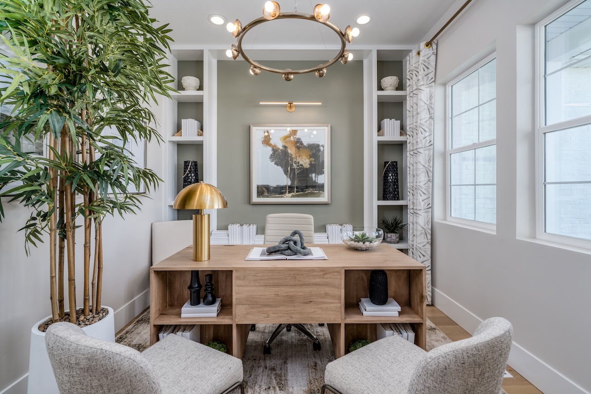 modern home office with a green accent wall and wooden desk with storage