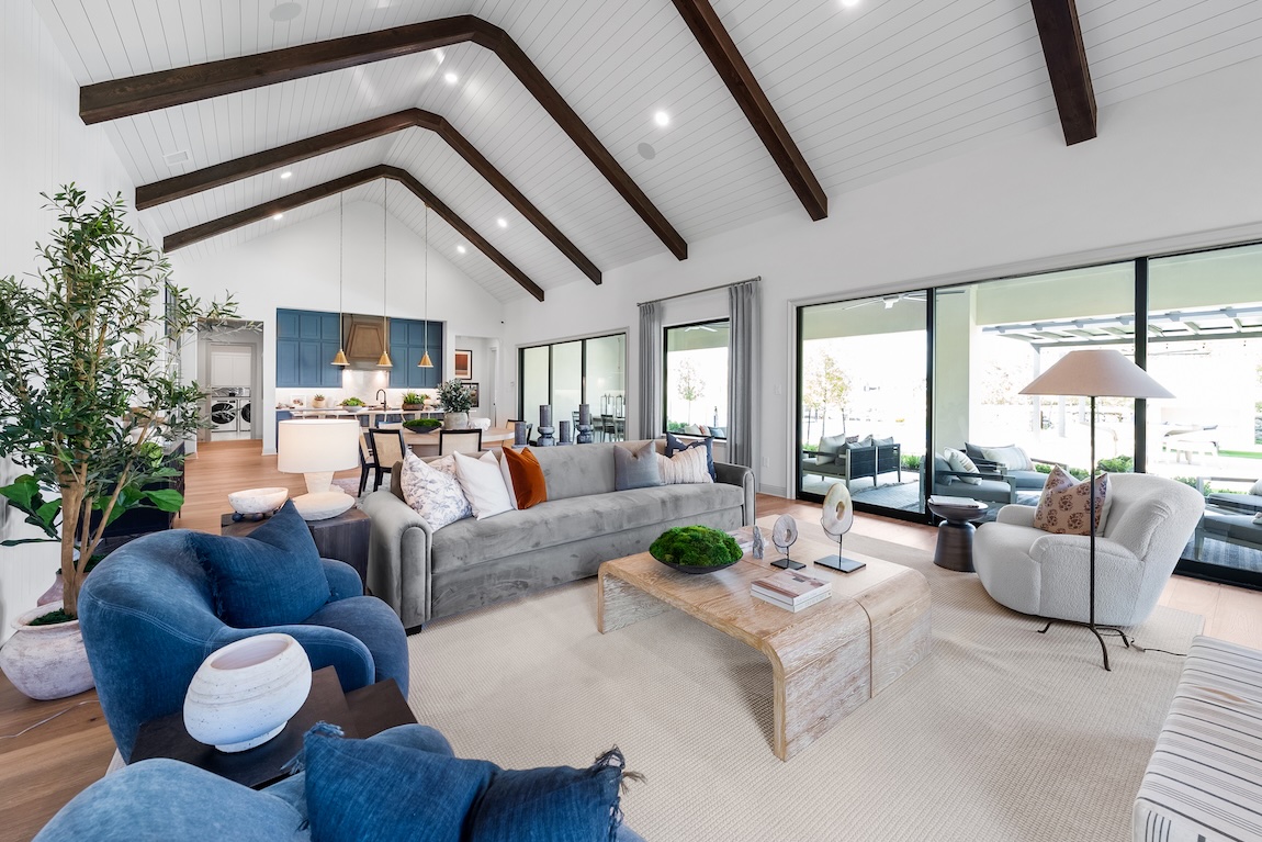 great room with blue seating and sliding doors to the outdoor living space