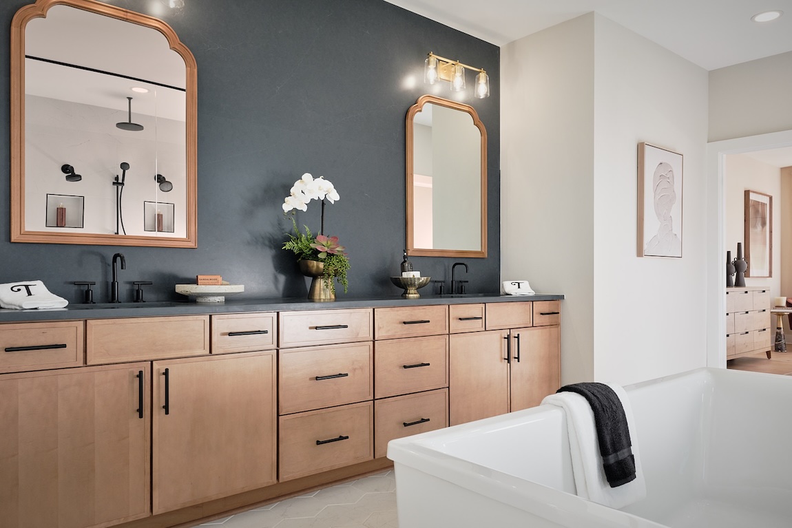 bathroom with dual vanities and dark statement accent wall