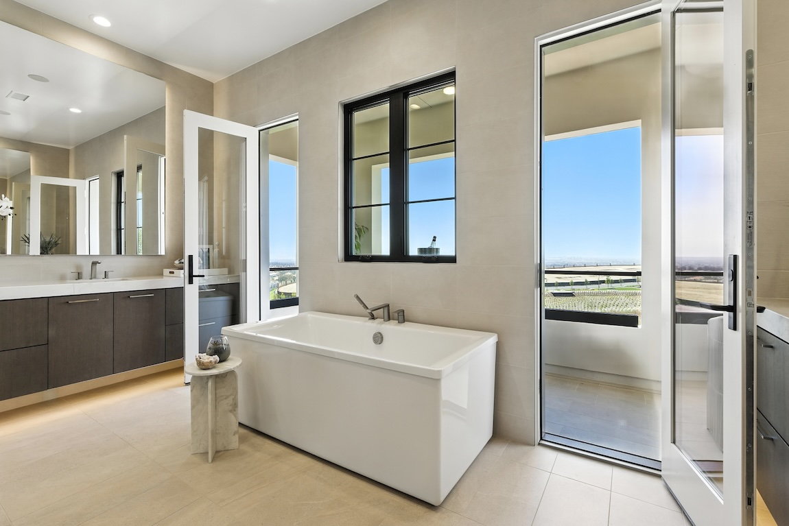 primary bathroom with freestanding tub and doors to the outdoor patio
