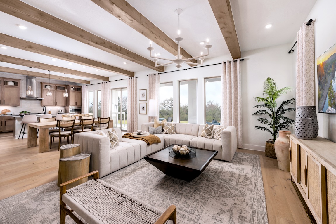 Fall interior design in an open-concept great room with exposed wood beams and layered neutral textures