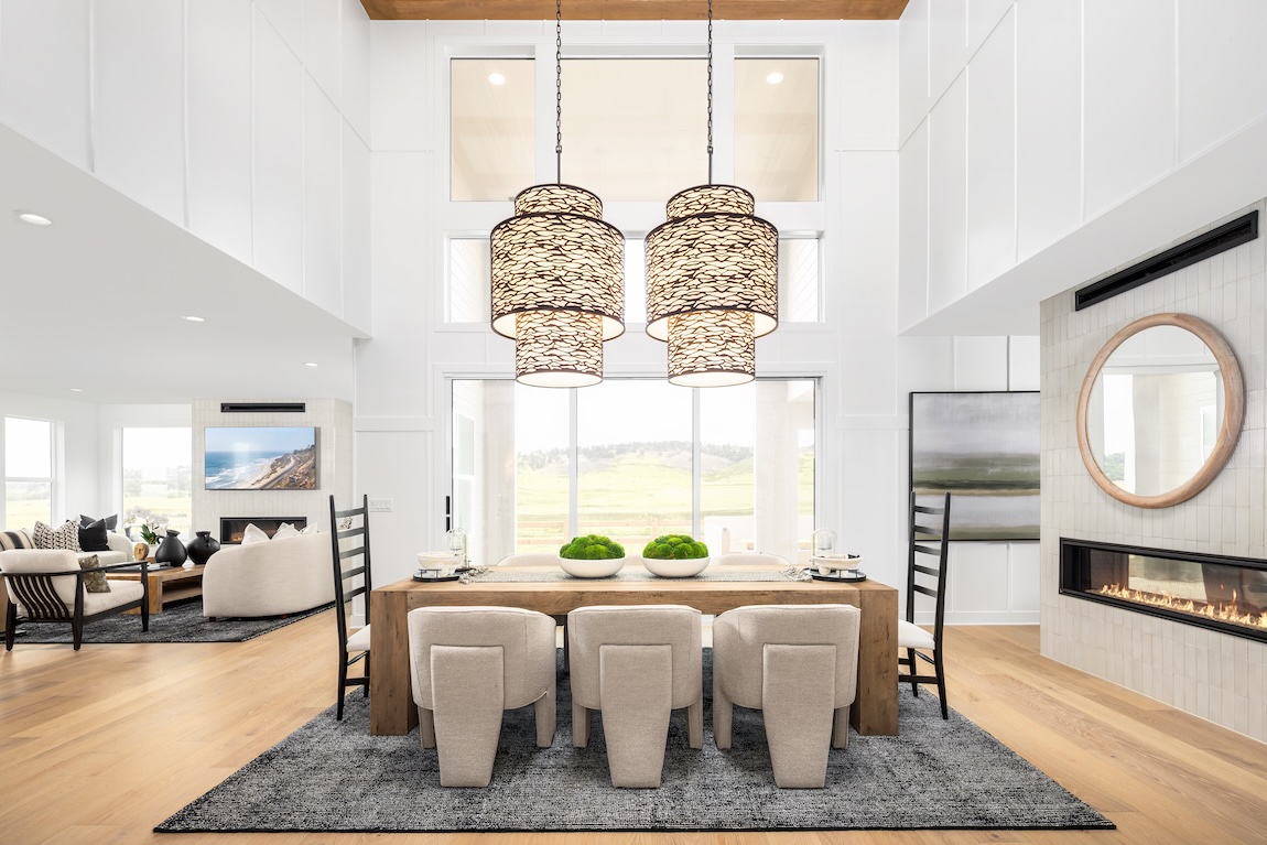 Dining room with oversized woven pendant lights, natural wood table, and warm neutral furnishings
