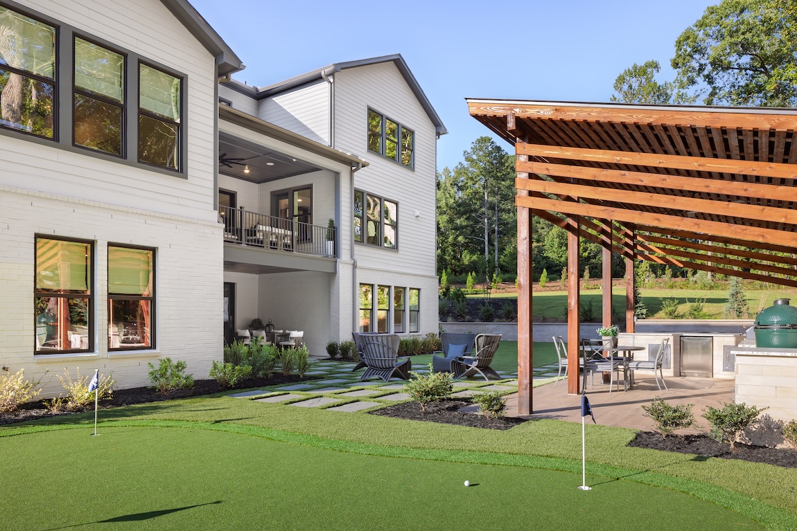 golf practice area in backyard with seating and kitchen space