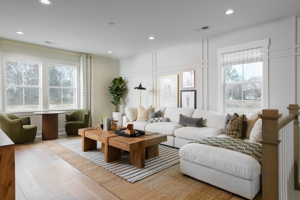 loft space with neutral tones and green accent chairs