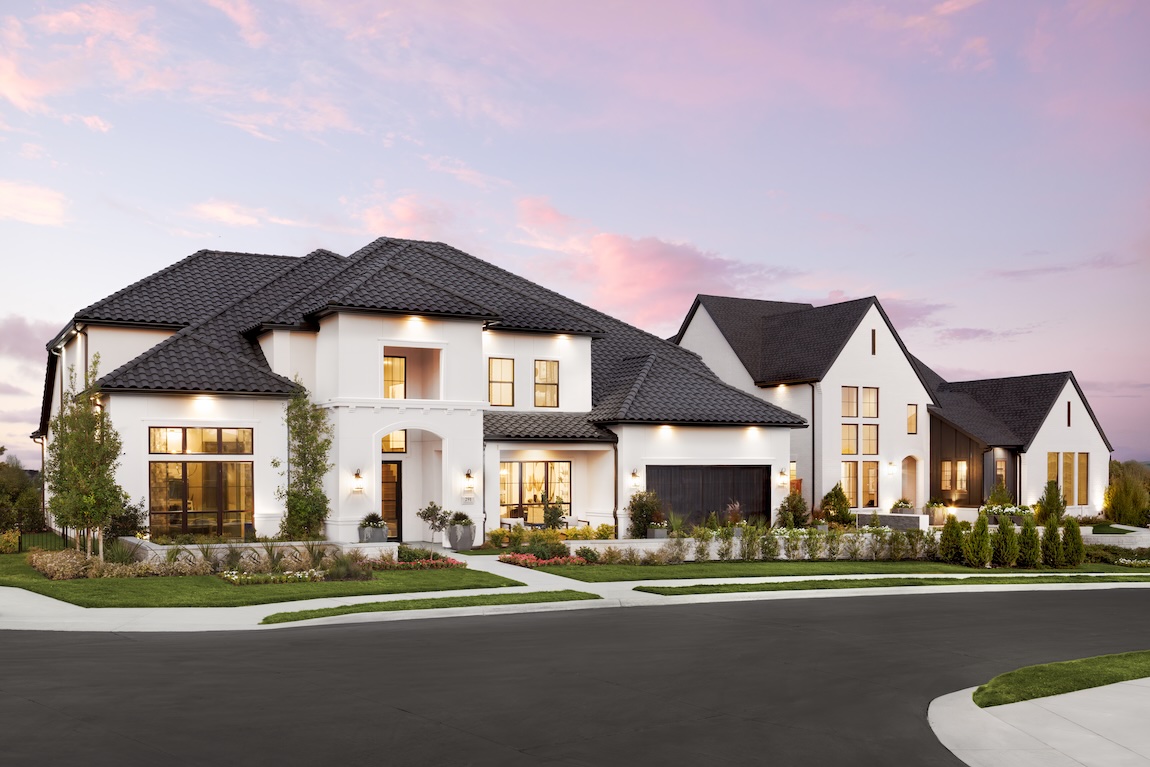exterior of home with green landscaping and large windows.
