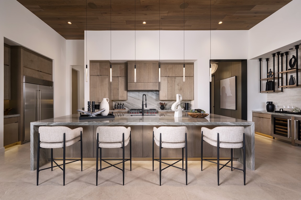 contemporary kitchen space with statement lighting and large waterfall island