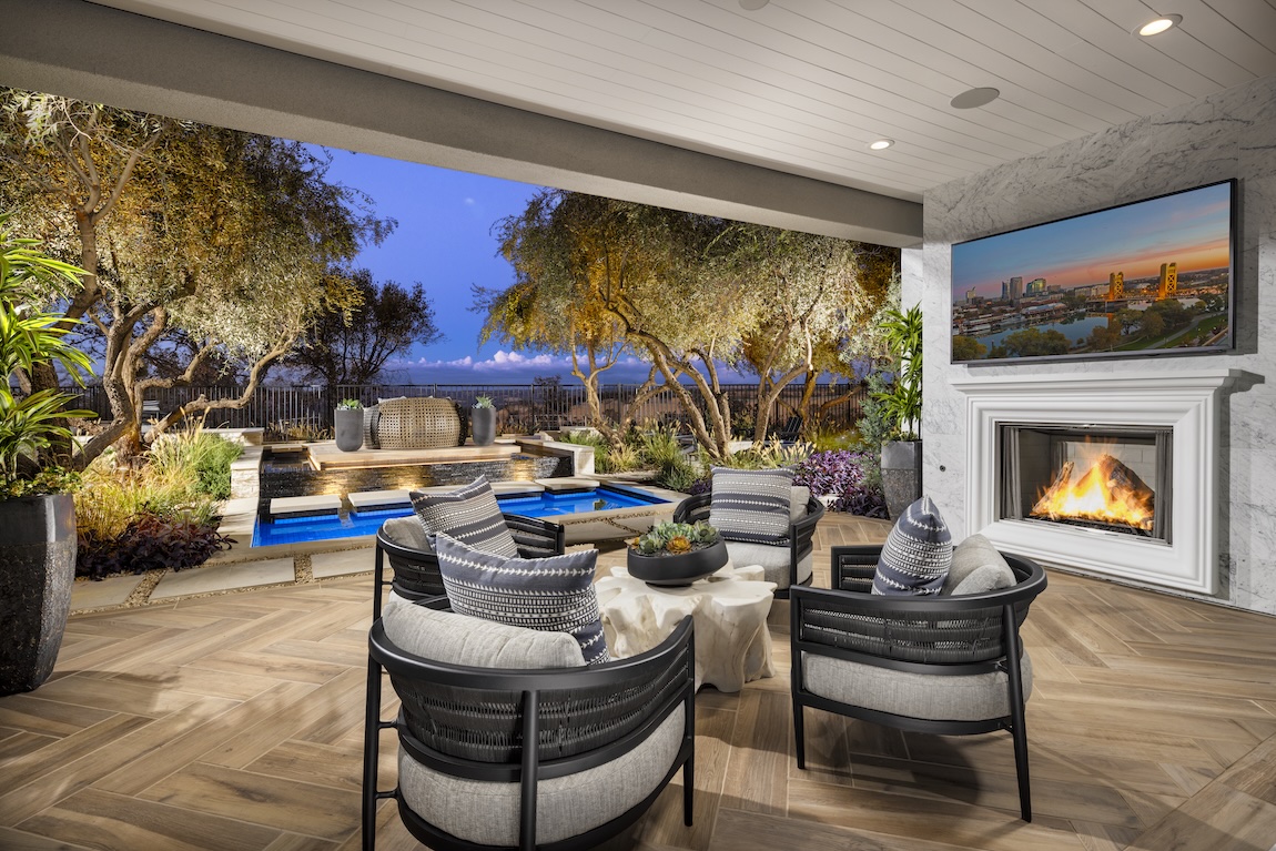 outdoor covered patio with fireplace and seating.