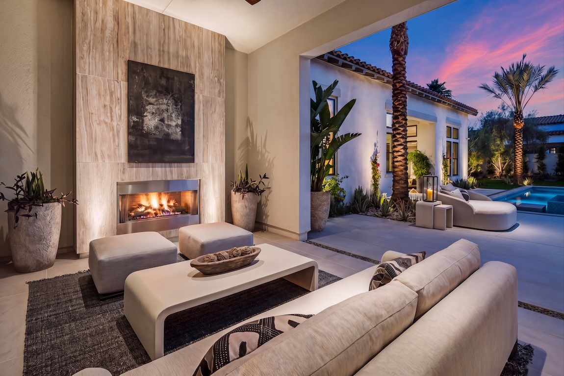 covered patio with couches and a fireplace