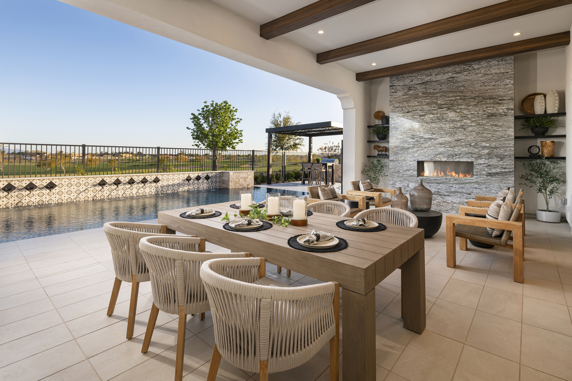 outdoor room highlighted by dining area and fireplace seating