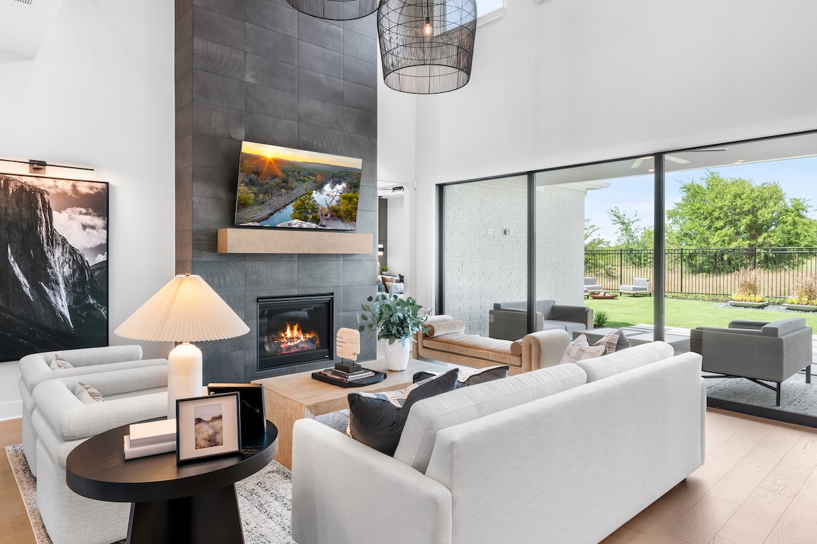 Bright living room with indoor-outdoor flow and a sleek fireplace beneath a mounted TV.