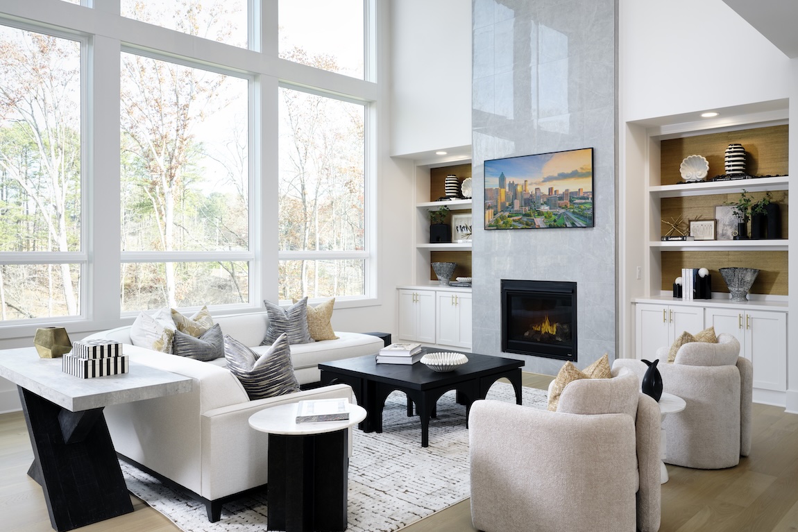Sunlit living space with floor-to-ceiling windows and sleek tile fireplace centerpiece.