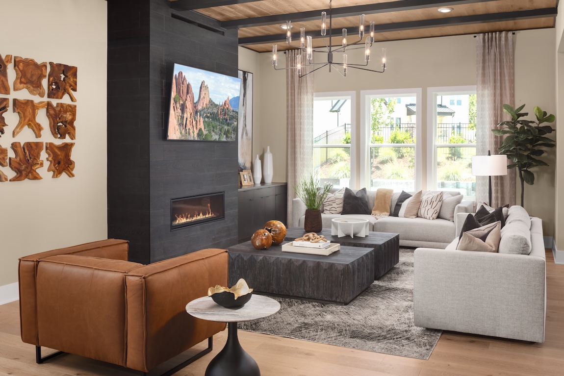 Modern living room with sleek black fireplace and warm neutral furnishings.